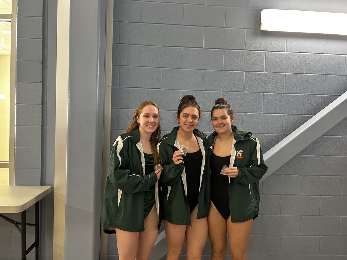 Three Kettle Run girls in team jackets holding up their medals