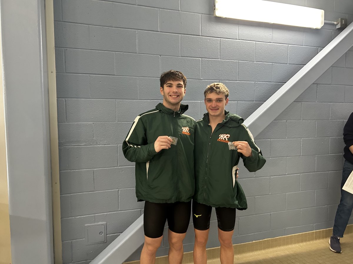 Two Kettle Run boys in team jackets holding up their medals
