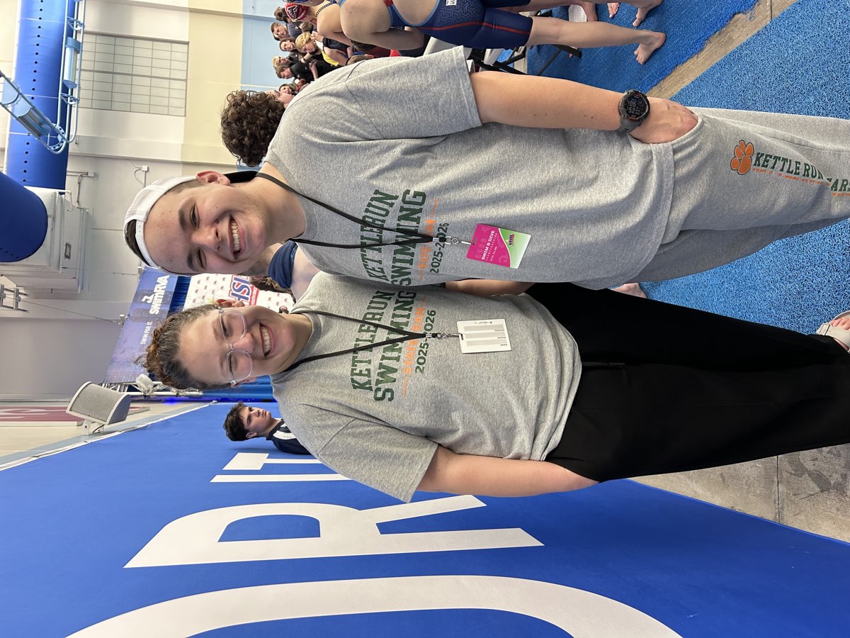 Two Kettle Run Swimming staff members in team shirts on the pool deck